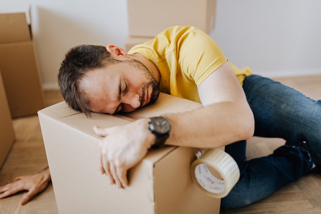 man tired when unpacking for moving homes